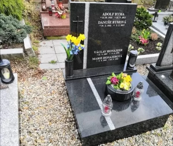 Moderní urnový hrob z luxusní černé žuly doplněný elegantním světlým dekoračním pruhem půs